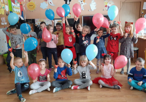 Grupa dzieci 5-6 letnich z balonami i serduszkami czekoladowymi